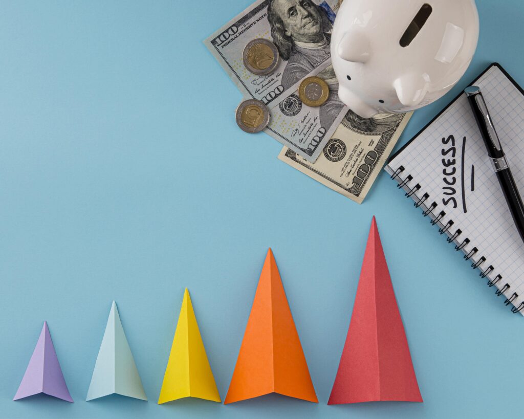 WooCommerce sales growth concept with colorful arrows, money, piggy bank, and success notebook — visualizing boosted conversions using WooCommerce plugins.